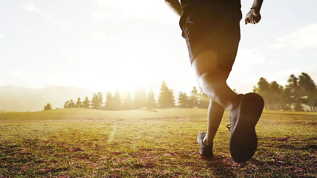 panoramic - man running marathon through the field