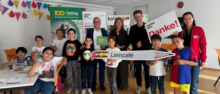 Viele Personen haben sich in einem Klassenzimmer zusammengestellt und lächeln in die Kamera