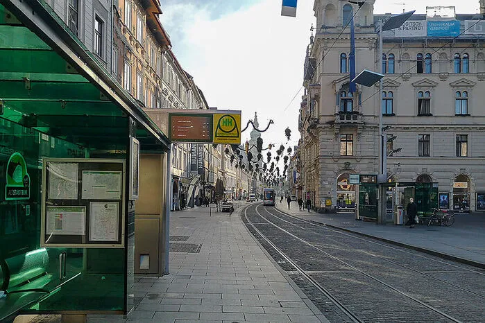 Ungewohnt leer ist auch der Hauptplatz und die Herrengasse. Vereinzelt warten Passanten auf die Straßenbahn oder spazieren zwischen den geschlossenen Geschäften.