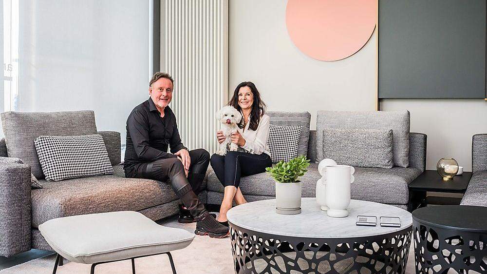 Barbara und Johann Osojnik gemeinsam mit ihrem Hund Paul auf einer Rolf Benz-Couch im neuen Möbelhaus