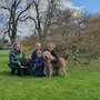 Das Bild zeigt drei Frauen und ein Kind sowie zwei Hunde auf einer Wiese. Das sind Noah mit Mama Stefanie in der Mitte und die beiden Assistenzhundetrainerinnen Birgit Dastig (r.) sowie Anni Hirschmann (l.)  | Birgit Dastig (r.) und Anni Hirschmann (l.) bilden als Assistenzhundetrainerinnen die elf Monate alte Hündin Lottie (schwarz) für die Familie Nadji - im Bild Noah mit Mama Stefanie - aus Gleisdorf aus