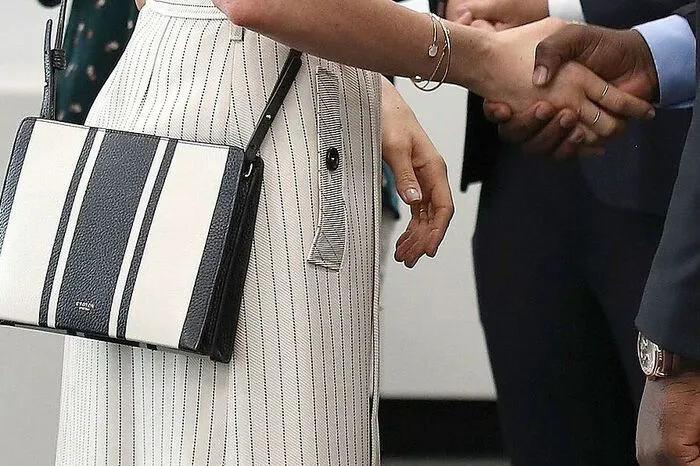 Tasche. Meistens auf die leichte Schulter genommen: Harrys Zukünftige liebt Umhängetaschen. (Madame Taussaud's: So sieht die Wachsfigur von Meghan Markle aus)