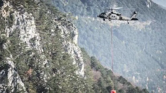 Man sieht einen Bundesheerhubschrauber beim Löschvorgang