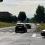 Blick auf eine Kreuzung, zwei Autos fahren auf der Vorrangstraße, ein Auto steht als Abbieger da