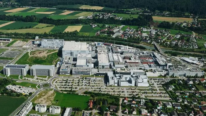 Panoramablick auf eine riesige Firma mit vielen verbundenen Hallen, Bürogebäuden, Parkplätzen und Parkhäusern