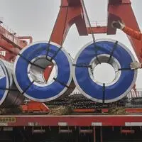 Ein Arbeiter verlädt Rollen von Stahlplatten auf einem Stahlmarkt in Hangzhou in der ostchinesischen Provinz Zhejiang