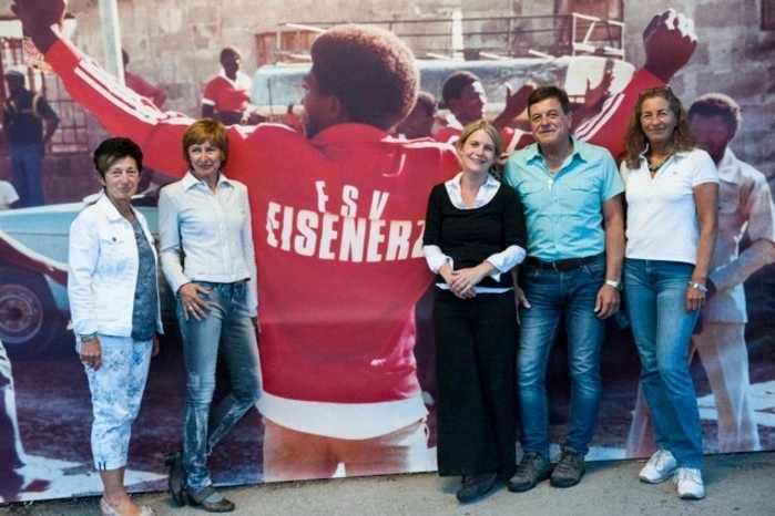 Ein exotischer Baum auf der einen Seite, und gegenüber ein Bild von Schwarzen, die Trikots des Eisenerzer Fussballclubs tragen... Wie es dazu kam, erzählte die Wiener Künstlerin Juma Hauser, die ihre mit Unterstützung des Instituts für Kunst im öffentlichen Raum Steiermark  (KIÖR) entstandene Wandinstallation und das im Mandelbaum Verlag neu erschienene Buch "Das Marampa Projekt" vorstellte.