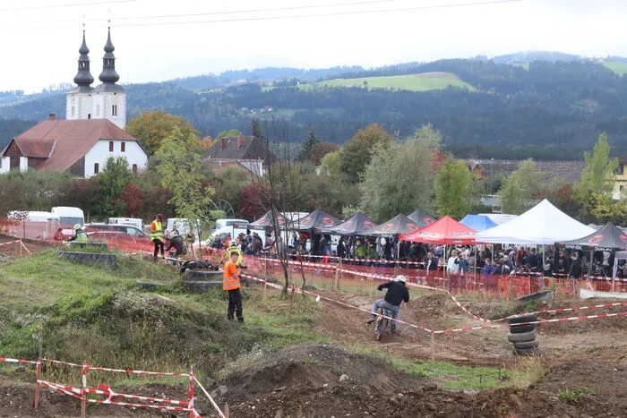 Eine einmalige Kulisse: die Rennstrecke mit der Boxenstraße und im Hintergrund die Pfarrkirche von St. Marein mit der Saualpe!