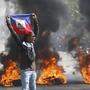 Ein Demonstrant hält eine haitianische Flagge während der Proteste für den Rücktritt von Premierminister Ariel Henry hoch 