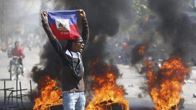 Ein Demonstrant hält eine haitianische Flagge während der Proteste für den Rücktritt von Premierminister Ariel Henry hoch 