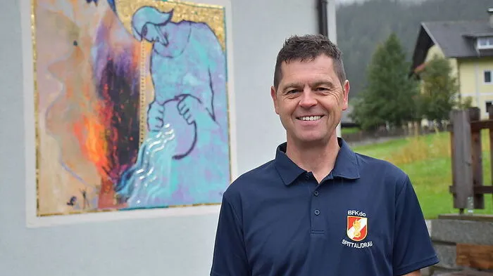 Kühbacher vor dem von Adi Holzer geschaffenen Goldmosaik am FF-Haus Reintal
