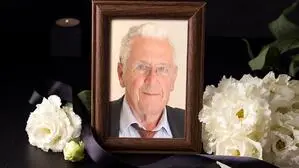 Mann mit weißen Haaren, Brille, Sakko, Hemd und Krawatte