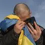 FILE - A recently swapped Ukrainian prisoner of war cries while calling his relatives after a prisoner exchange on the Ukrainian Russian border, on Wednesday, Jan. 31, 2024. U.N.-backed human rights experts said Friday March 15, 2024 they have gathered new evidence of “horrific” torture of Ukrainian prisoners of war by their Russian jailers, saying such practices could amount to war crimes. (AP Photo/Danylo Pavlov, File)