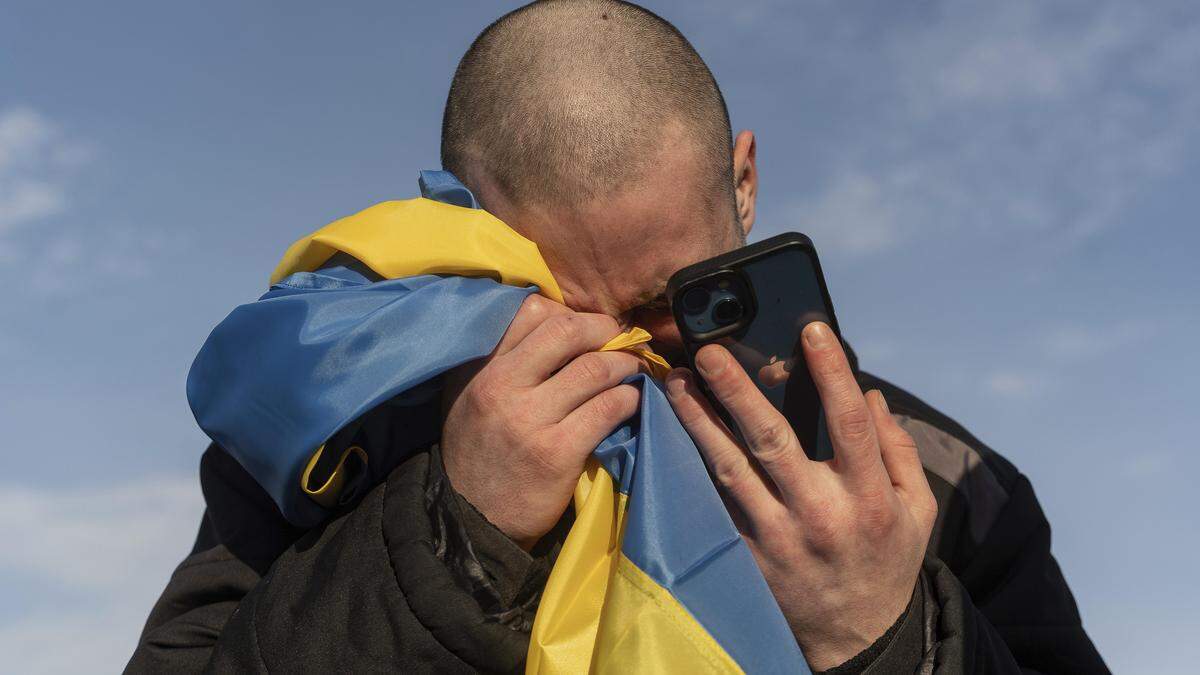 Ein freigelassener ukrainischer Kriegsgefangener ruft nach einem Gefangenenaustausch an der ukrainisch-russischen Grenze weinend seine Angehörigen an