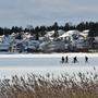 Menschen spazieren über einen gefrorenen See in Lahti