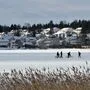 Menschen spazieren über einen gefrorenen See in Lahti