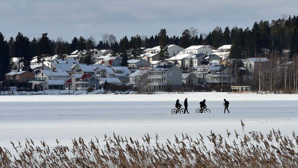 Menschen spazieren über einen gefrorenen See in Lahti