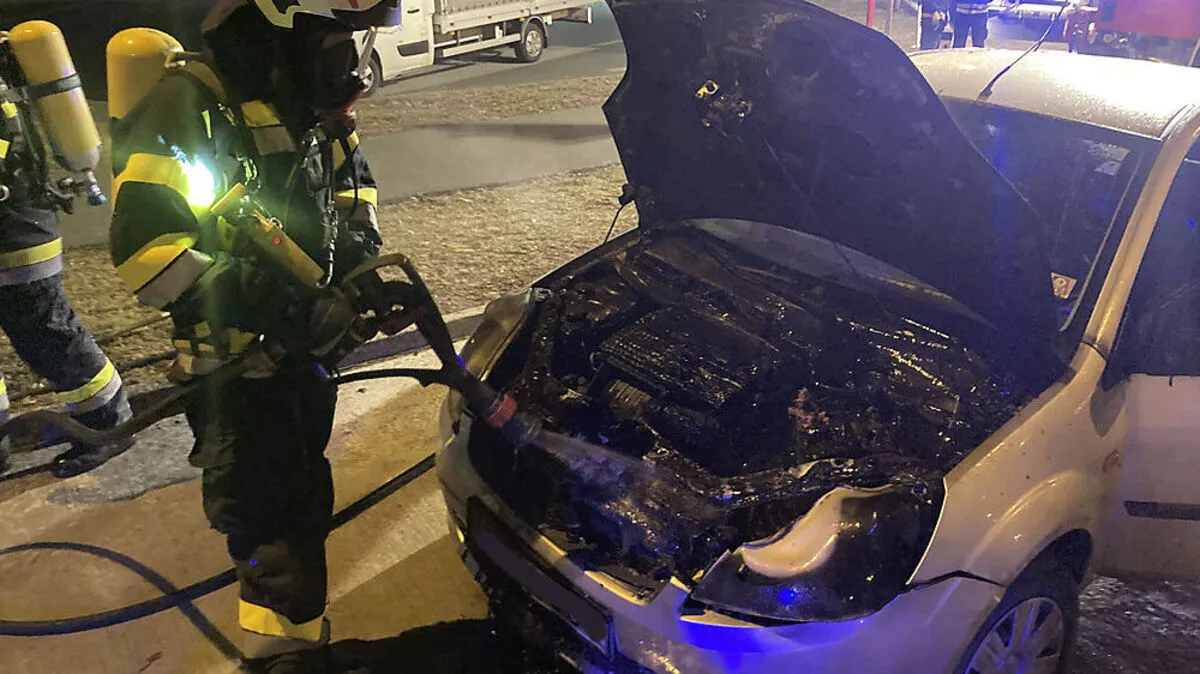 Feuerwehrleute beim Löschen des Brandes im Motorraum