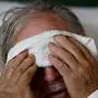 FILE - In this Friday, Feb. 9, 2018 file photo, a 73-year-old man places a cold compress on his forehead while battling the flu at a hospital in Georgia. Doctors can test for the flu and get results within a day, but coronavirus testing as of March 2020 is still limited in the United States by availability. (AP Photo/David Goldman)