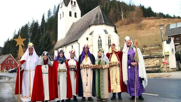 Die beiden Erwachsenen-Gruppen sind im Rahmen der Sternsingeraktion im Bergdorf Salla unterwegs
