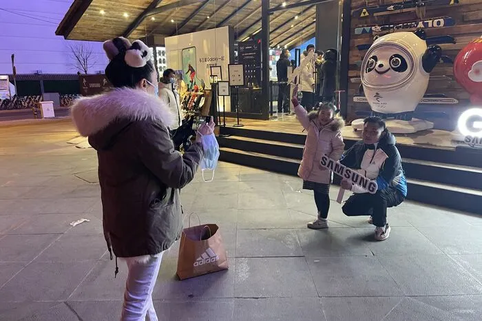 Für die Pekinger scheint ein Leben ohne Bing Dwen Dwen zwar noch möglich, aber nicht sinnvoll zu sein. In der berühmtesten Einkaufsstraße, in Wangfujing, bilden sich regelmäßig lange Warteschlangen vor Geschäften, die das Olympia-Maskottchen verkaufen. 
