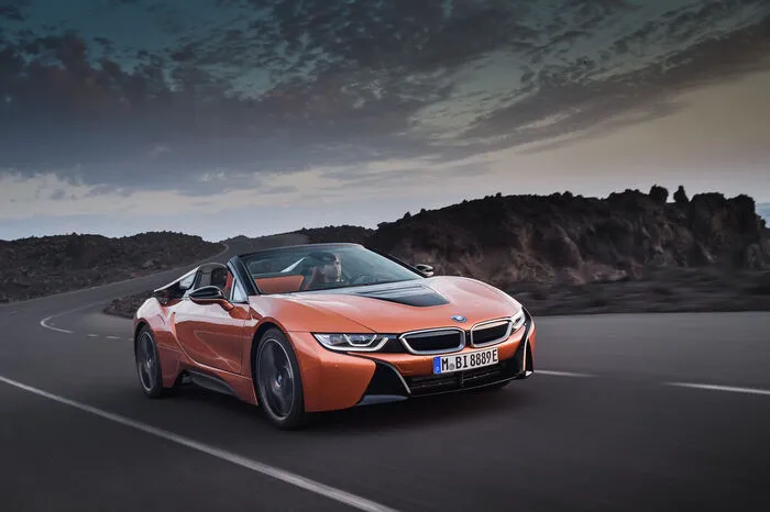 Parallel zur weiterentwickelten Ausführung des Coupés geht jetzt der neue BMW i8 Roadster an den Start. Der Zweisitzer mit elektrischem Stoffverdeck baut wie auch der 2+2 auf einem Aluminium-Chassis in Kombination mit einer Fahrgastzelle aus carbonfaserverstärktem Kunststoff, was ein Gewicht von 1593 Kilogramm ergibt.