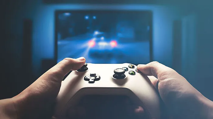 Video gaming console. Man playing car racing