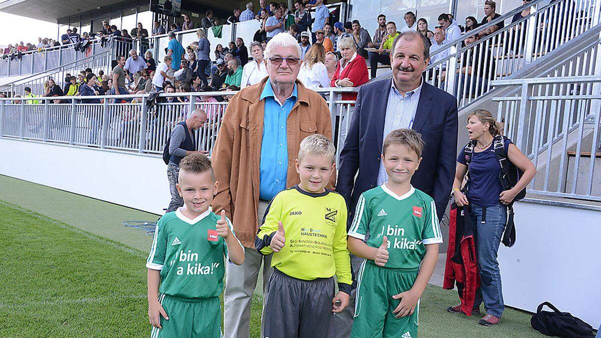 Landskrons Langszeitobmann Hubert Sabetzer und der jetztige Obmann Wilfried Willegger mit U8-Spielern des SC Landskron bei der Eröffnung des Sportzentrums