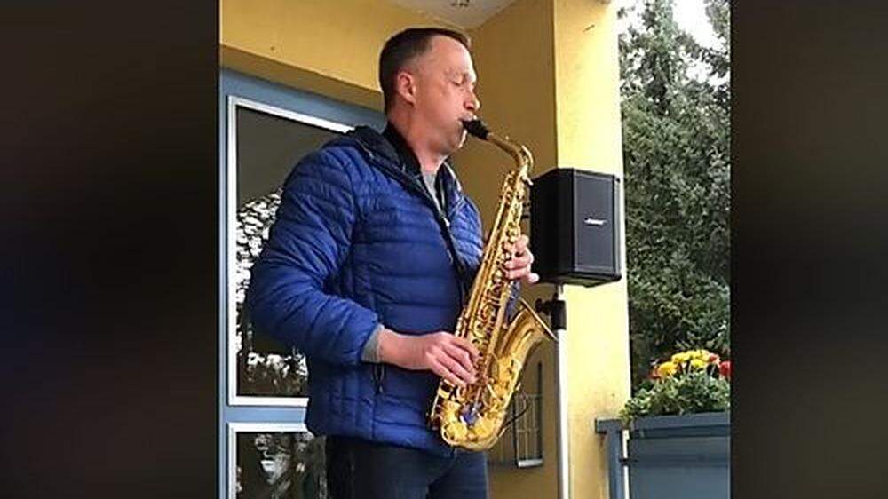Harald Krahser spielt Saxofon auf dem Parkplatz seines Wohnhauses