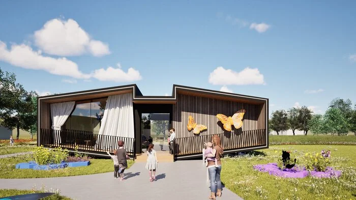 Ein modernes Holzgebäude mit zwei gelben Schmetterlingen an der Fassade