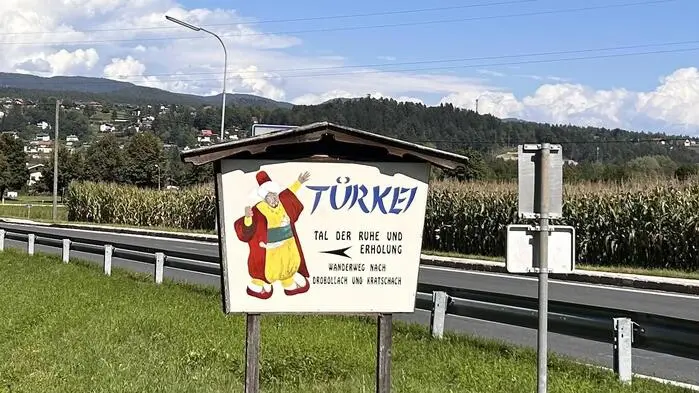 Ortsschild auf einer grünen Wiese neben einer Straße mit der Aufschrift „Türke“