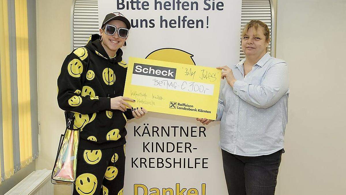 Ian Jules übergibt den Scheck an Gabriele Lebitschnig von der Kinderkrebshilfe