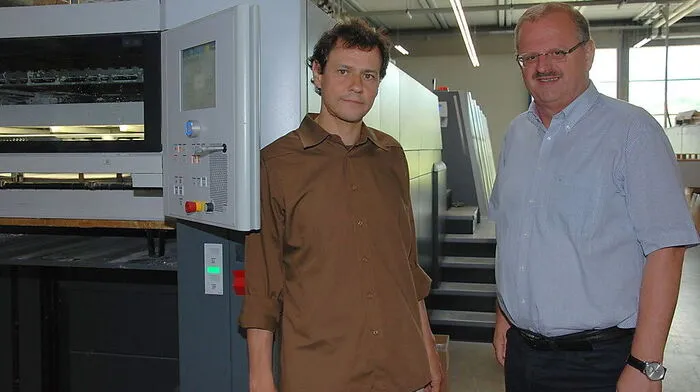 Firmenchef Christian Theiss und Betriebsleiter Peter Sarny vor der neuen 15 Meter langen Druckmaschine 