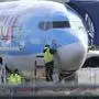 A worker stands on a platform near a Boeing 737 MAX 8 airplane being built for TUI Group at Boeing Co.'s Renton Assembly Plant Wednesday, March 13, 2019, in Renton, Wash. President Donald Trump says the U.S. is issuing an emergency order grounding all Boeing 737 Max 8 and Max 9 aircraft in the wake of a crash of an Ethiopian Airliner. (AP Photo/Ted S. Warren)
