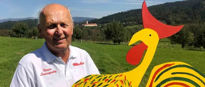 Ein Mann hält ein großes, gebasteltes Huhn in seinen Händen 