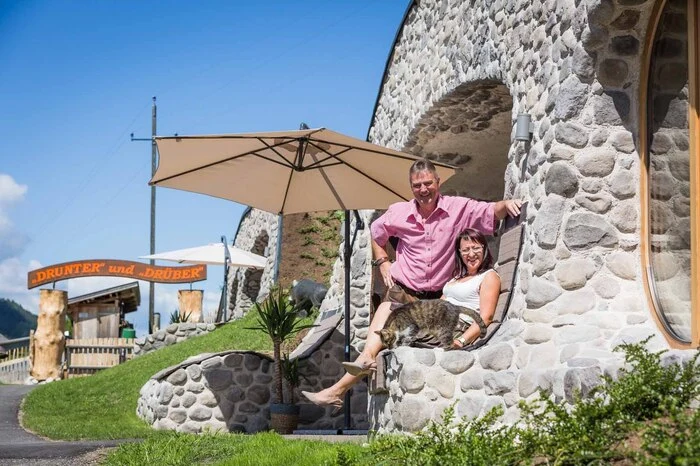 Werner und Petra Morgenfurt auf ihrem persönlichen Lieblingsplatzerl: der Steinliege bei der Terrasse eines der beiden Erdhäuser.