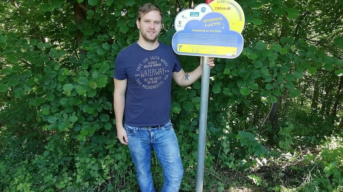 Stephan Stückler (KLAR-Manager) mit einer Stationstafel des Klimawanderweges