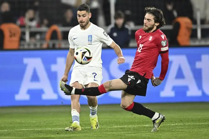 Greece's Giorgos Masouras, left, fights for the ball with Georgia's Otar Kiteishvili during the Euro 2024 qualifying play-off soccer match between Georgia and Greece at the Boris Paichadze National Stadium in Tbilisi, Georgia, Tuesday, March 26, 2024. (AP Photo/Tamuna Kulumbegashvili)