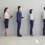 Job seekers wearing face masks standing in row keeping safe distance while waiting for job interview