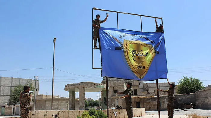 Kurdische Kämpfer montieren ihre Flagge im Zentrum von Manbij