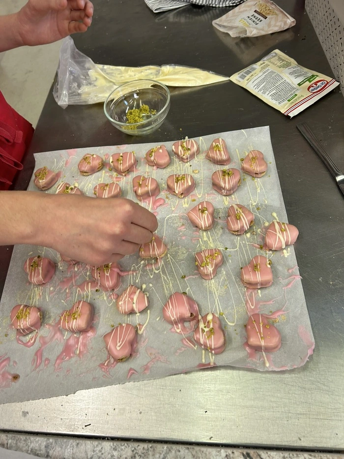 Die glasierten Herzen mit weißer Kuvertüre in einer Spritztülle verzieren und gehackten Pistazien bestreuen. Sieht wunderschön aus und schmeckt hervorragend. 