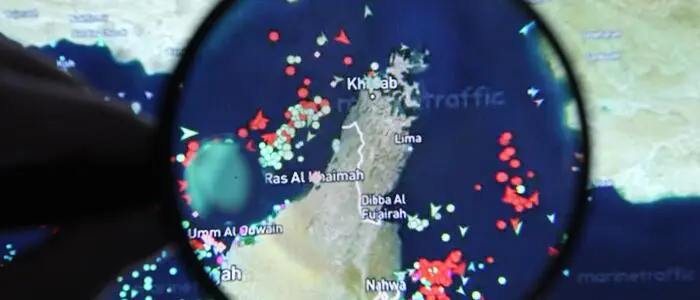 Lupe vergrößert einen Kartenauschnitt der Straße von Hormuz