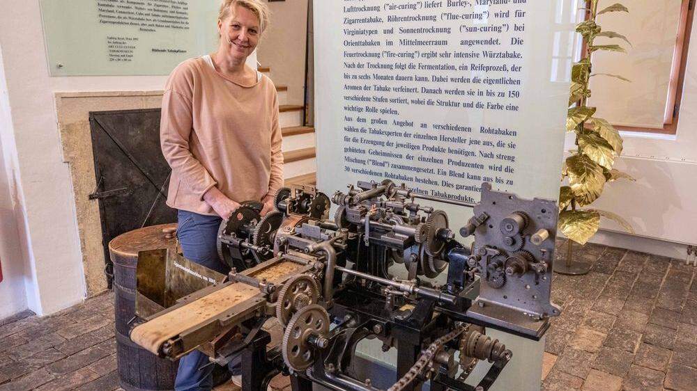 Museumsleiterin Gaby Jedliczka mit der  Zigarettenstopfmaschine „La Neva“ in der Fürstenfelder Pfeilburg 