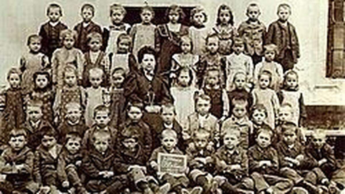 Schöne Schürzchen und Nagelschuhe fürs Foto: Trotzdem wirken diese Bleiberger Volksschüler von 1911 nicht sehr glücklich 	