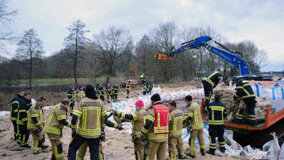 Feuerwehrleute sichern einen Deich bei Sandkrug | Feuerwehrleute sichern einen Deich bei Sandkrug