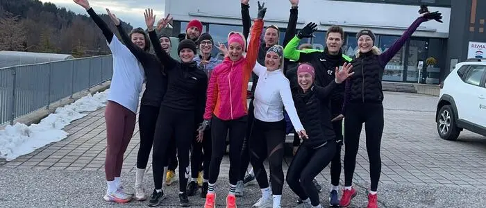 Mehrere Menschen in Sportbekleidung lachen in die Kamera