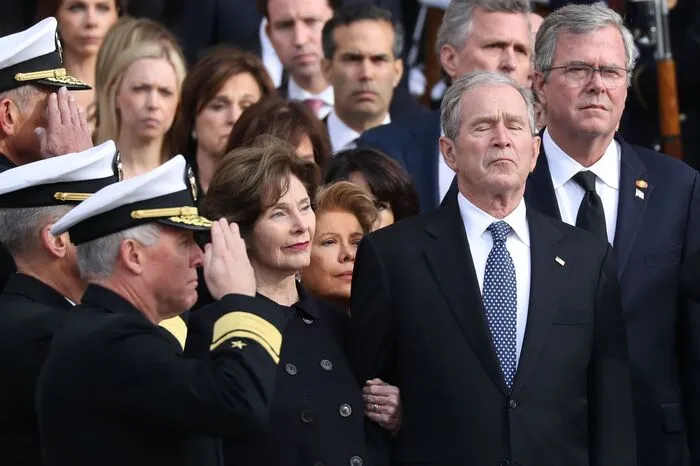 Sein mit der US-Flagge bedeckter Sarg wurde dann unter militärischem Zeremoniell aus dem Kapitol getragen. Dabei wurden Salutschüsse aus Kanonen abgefeuert, und eine Militärkapelle spielte "Hail to the Chief", die offizielle Hymne für die US-Präsidenten.