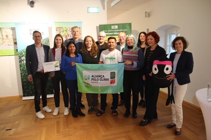 Fritz Hofer (Klimabündnis Steiermark), Raphaela Fink (Steirisches Vulkanland), Janete Figueredo Alves, Bürgermeister Johann Winkelmaier (Fehring), Ana-Letícia Pastore Trindade, Bürgermeister Ferdinand Groß (Kapfenstein), Dario Casimiro Baniwa, Bürgermeister Robert Hammer, Kerstin Bär (Klimabündnis Österreich), Tamara Petschnigg (Klimabündnis Steiermark), Landtagsabgeordnete Cornelia Schweiner, Maskottchen Edgar und Maria Eder (Klima- und Energiemodellregion Netzwerk Südost) bei der Eröffnung