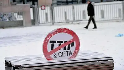 A picture taken on January 23, 2017 shows a crossed sign reading "Transatlantic Trade and Investment Partnership (TTIP) & EU-Canada Comprehensive Economic and Trade Agreement (CETA)" in front of the main entrance of the European Council covered with milk powder after European Milk Board (EMB) representatives sprayed it during a demonstration on the side of a meeting of EU ministers of agriculture, in Brussels.
Demonstrators protested on January 23 against the European Commission's decision to gradually reinstate withdrawn milk powder stocks, in an attempt to stabilise the price, at the height of a crisis of overproduction. / AFP PHOTO / EMMANUEL DUNAND