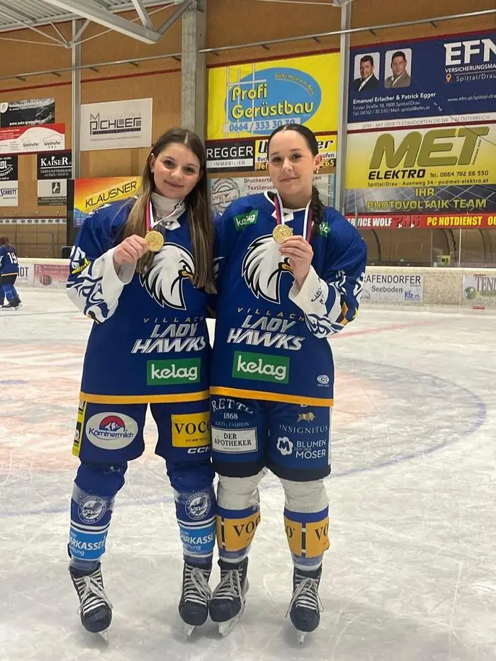 Siri Zimmermann feiert gemeinsam mit einer Teamkollegin den Meistertitel – mit Goldmedaille und strahlenden Gesichtern im Dress der Villach Lady Hawks
